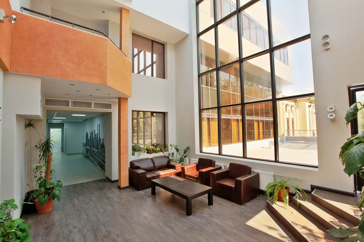 Tall atrium lobby with leather seating and a wall of windows