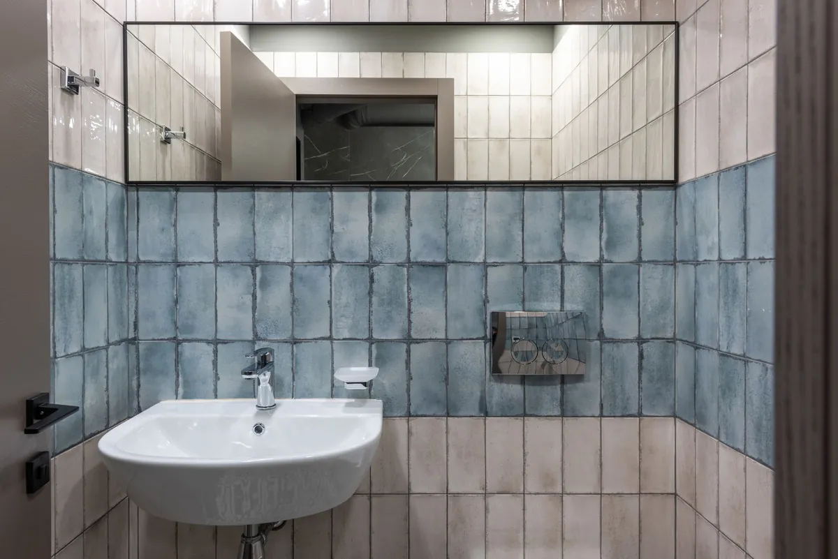 Bathroom with blue tile and a wall-hung sink