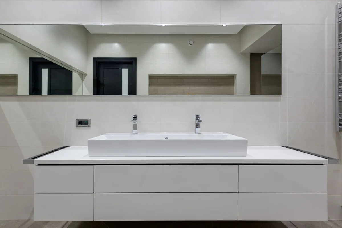White bathroom vanity with a long mirror