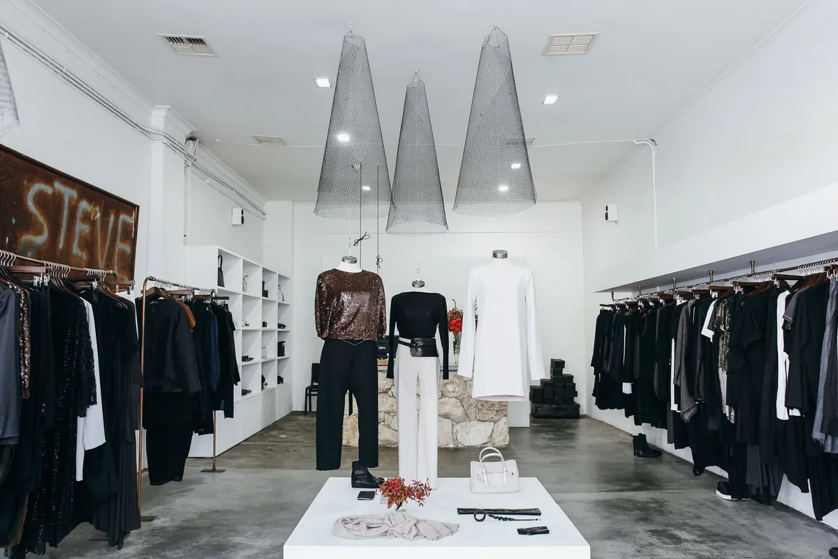 Boutique with black garments on white shelving