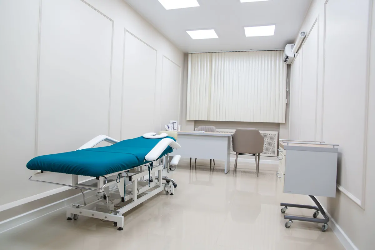 Exam room with a teal treatment table and white walls