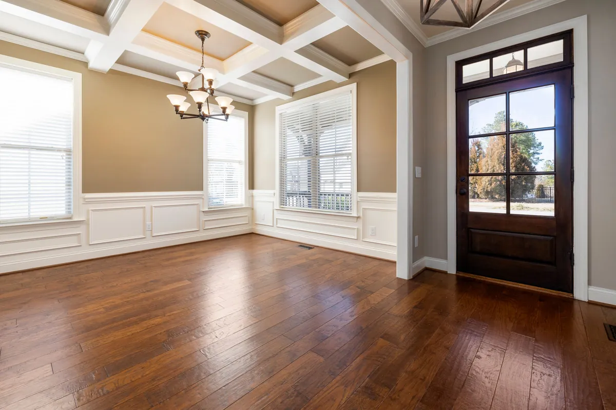 Finished room with hardwood floors, wainscoting and a front door