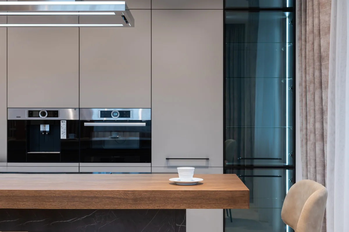 Modern kitchen with wall ovens and a wood counter
