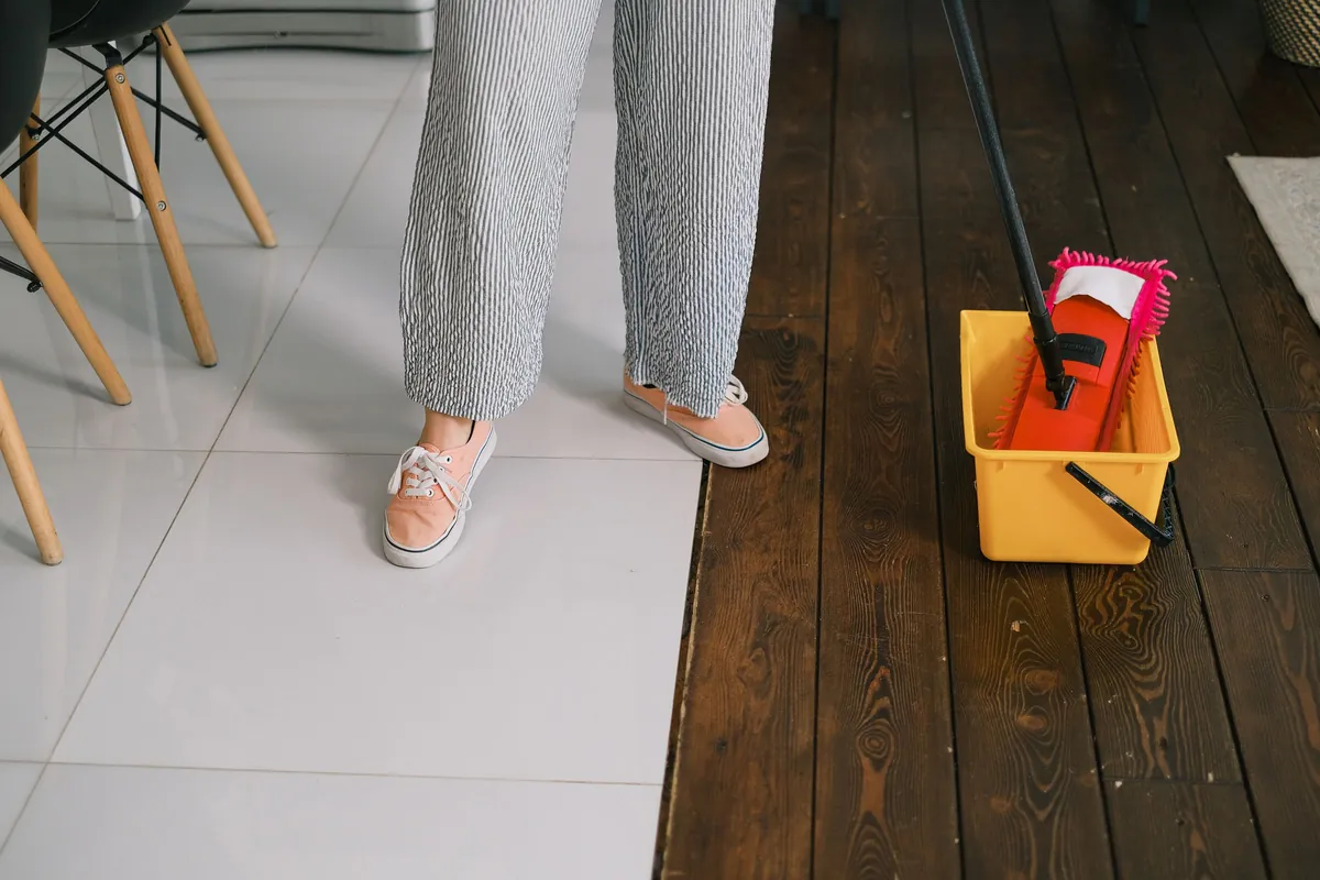 A mop and bucket on a wood floor