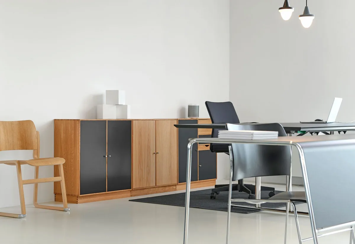 Quiet office corner with a wood credenza and a black desk chair