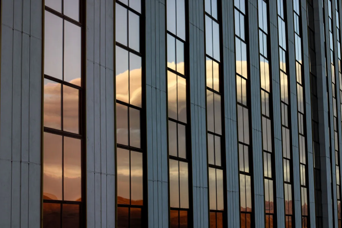 Glass office building reflecting a Reno sunset