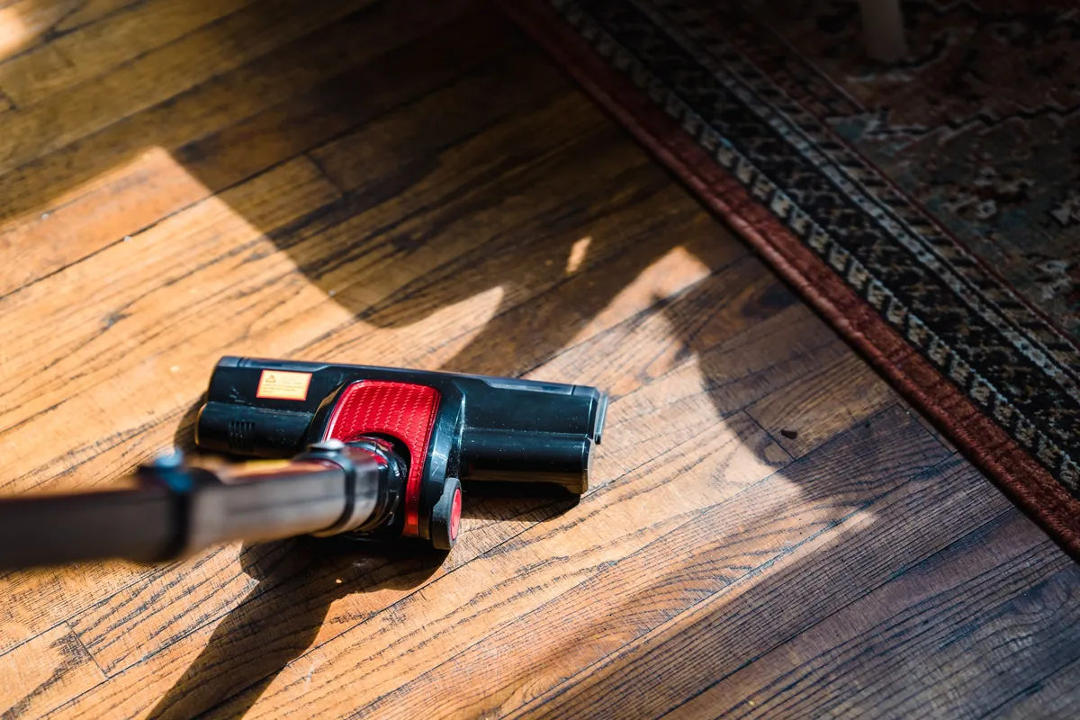 A vacuum head on a sunlit wood floor
